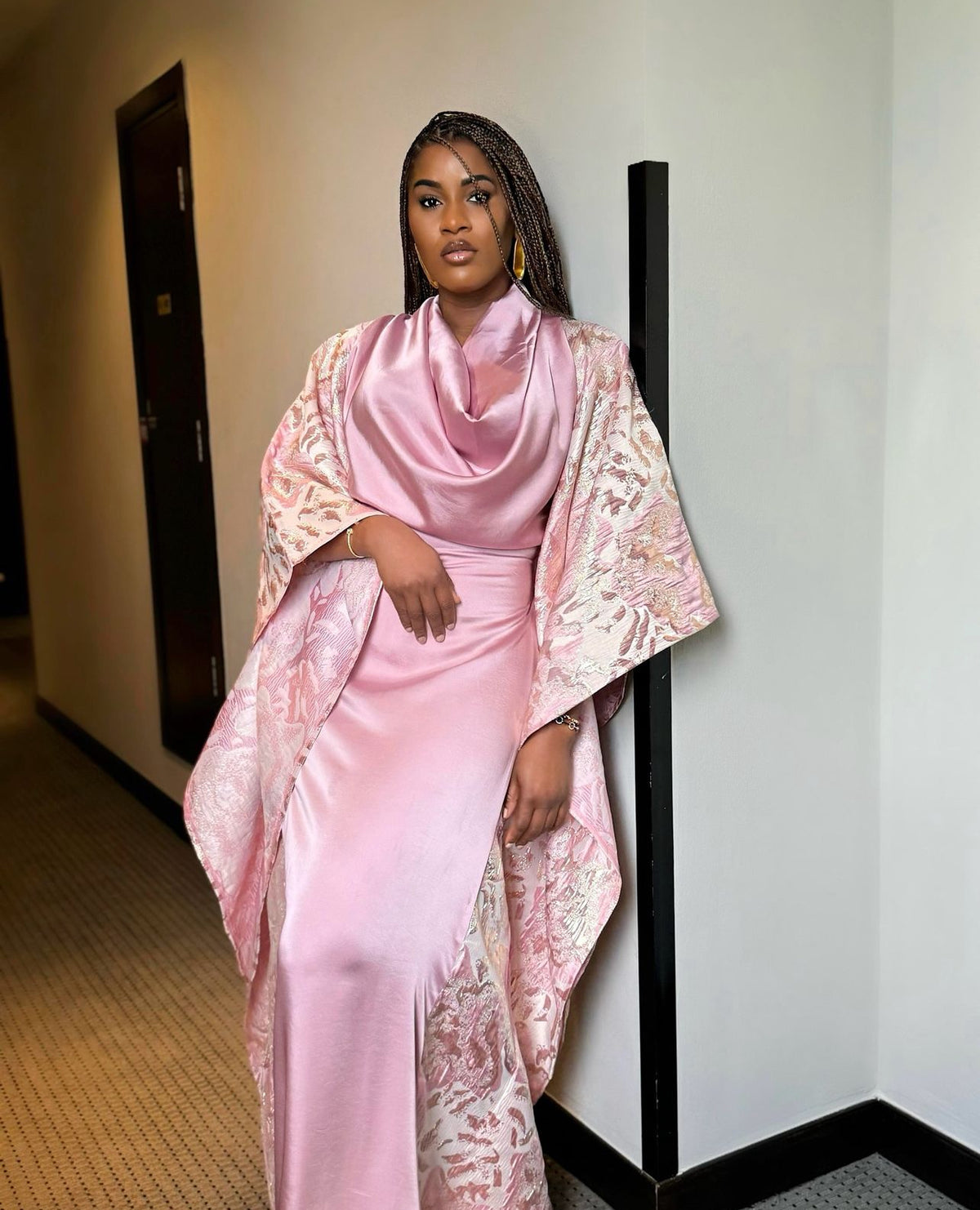 Woman wearing a pink Moremi Boubou with a draped neckline and floral cape.
