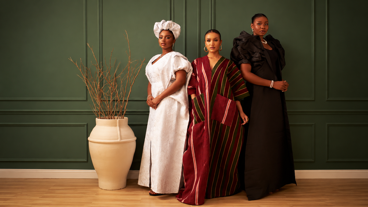 Three women in a white kaftan, a burgundy striped kaftan, and a black dress.
